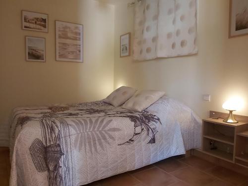 - une chambre avec un lit et une lampe sur une table de chevet dans l'établissement Le Lézard pâle, à Corneilla-la-Rivière