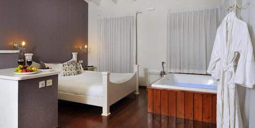 a bathroom with a bed and a bath tub at לה פאצה - בריכה פרטית in Had Nes
