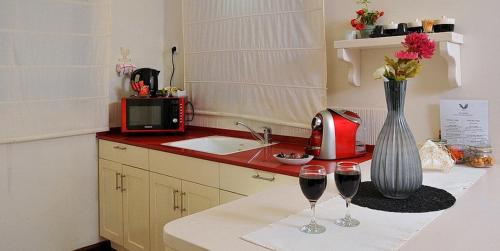 a kitchen with two glasses of wine on a counter at לה פאצה - בריכה פרטית in Had Nes