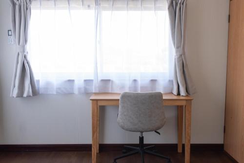 a chair sitting at a desk in front of a window at 富江宿 in Tomie