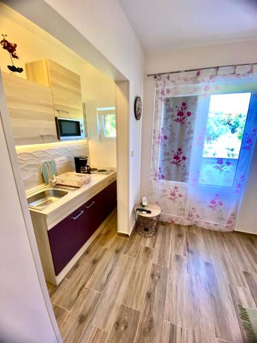 a kitchen with a sink and a window at Apartman Miljenko - Matovica in Kampor