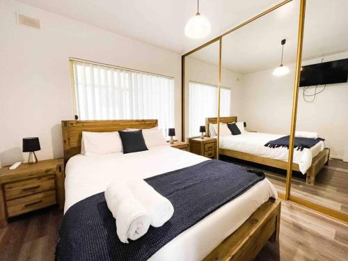 a bedroom with two beds and a mirror at entire beachfront apartment 5 Esplanades seaviews in Glenelg
