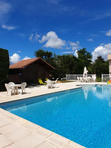a swimming pool with chairs and a house at Brit Hotel Dak Hotel in Avallon