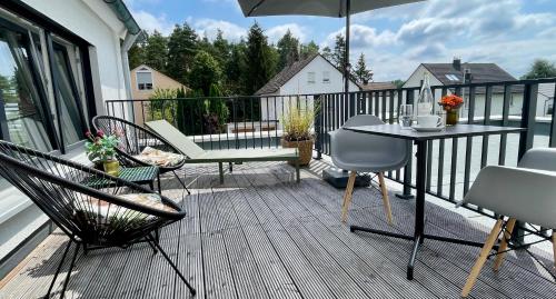 a balcony with a table and chairs and an umbrella at Apartment Living in Schwabach