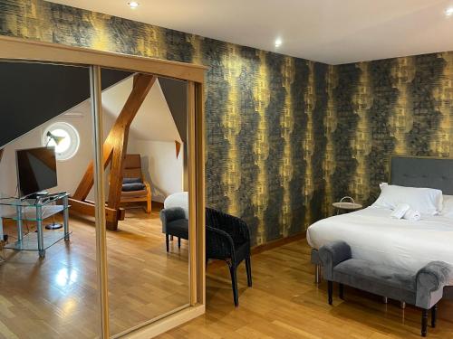 une chambre avec un lit et un miroir dans l'établissement Villa Louise, à Arromanches-les-Bains