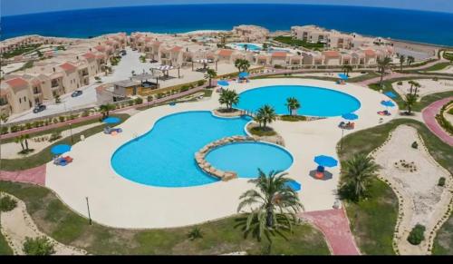 an aerial view of a resort with two pools at Coral hills North Coast كورال هيلز الساحل الشمالي in Al Dabaa