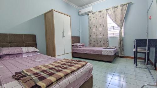 a bedroom with two beds and a window at Bunut Centre Stay in Bandar Seri Begawan