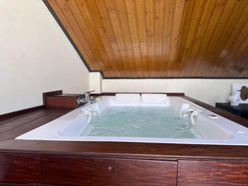 a large bath tub with a wooden ceiling at Casa Capricho in San Martín de Valdeiglesias