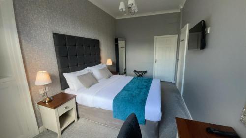 a bedroom with a large white bed with a blue blanket at Virginia House, Ulverston in Ulverston