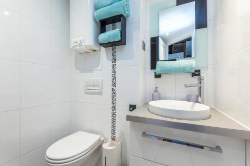 une salle de bain blanche avec des toilettes et un lavabo dans l'établissement Lipstick Port Nature, au Cap d'Agde