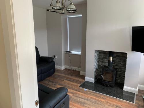 a living room with a fireplace and a couch at Mourne Country Cottage in Warrenpoint