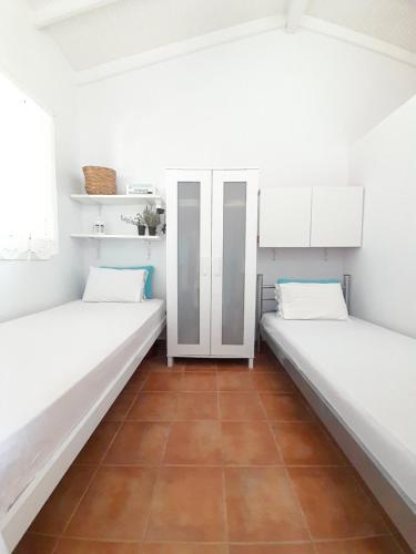 two beds in a room with white walls at Vasiliki in Kavála