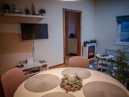 a living room with a table with chairs and a fireplace at STAR apartman Brzece Kopaonik in Brzeće