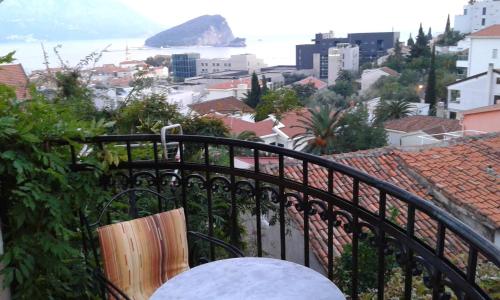 a bench sitting on a balcony overlooking a city at Apartmani Vila Marija in Budva