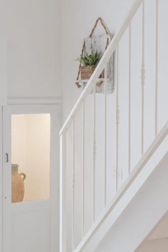 a white staircase with a basket of plants on it at CENTO FOGLIE la dimora del borgo in Felline