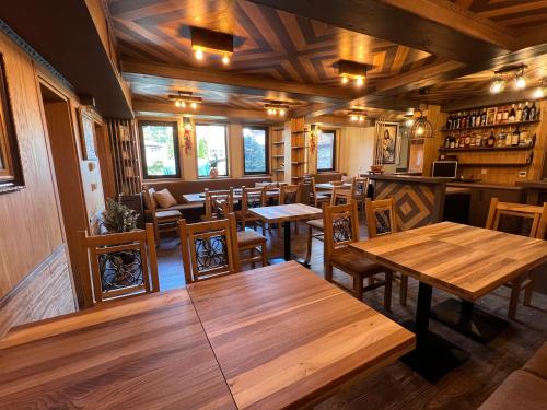 an empty restaurant with wooden tables and chairs at Китанова къща in Koprivshtitsa