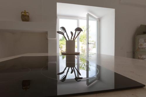a glass table with a vase on top of it at CENTO FOGLIE la dimora del borgo in Felline
