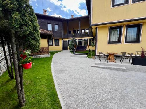a courtyard of a house with a table and chairs at Китанова къща in Koprivshtitsa