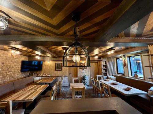 a dining room with wooden ceilings and wooden tables at Китанова къща in Koprivshtitsa