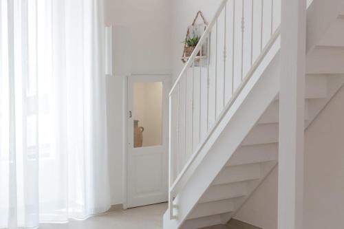 a white staircase in a home with white walls at CENTO FOGLIE la dimora del borgo in Felline