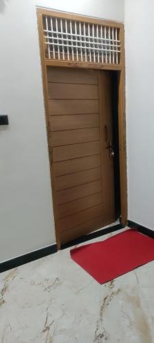 Una puerta con una alfombra roja en una habitación. en The Dreem House of S Pandey, en Prayagraj