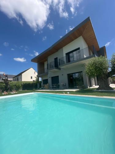 a villa with a swimming pool in front of a house at Villa Marina in LʼIsle-Adam