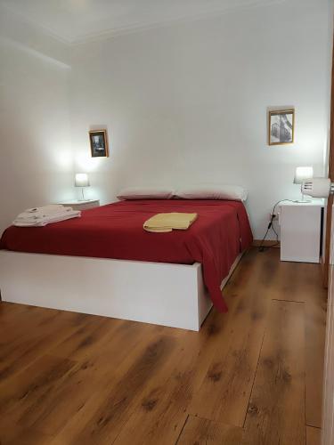 a bedroom with a large bed with a red blanket at Casa da Avo Maria - 2 in Podence