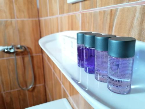 three bottles of toothpaste sitting on a shelf in a bathroom at Casa din Vamă in Vama Veche