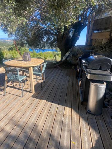 a wooden deck with a table and a grill at A Malgrana - Tente lodge hébergement insolite in Coti-Chiavari
