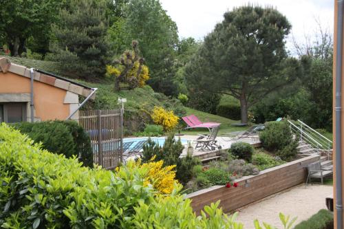 a garden with a bench and a table and chairs at La Bastide de Fontaille in Saint-Félicien