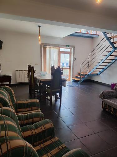 a living room with a table and chairs and a staircase at Casa da Avo Maria - 2 in Podence