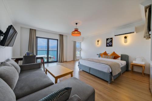 a bedroom with a king sized bed and a couch at Körfez Residence in Fethiye