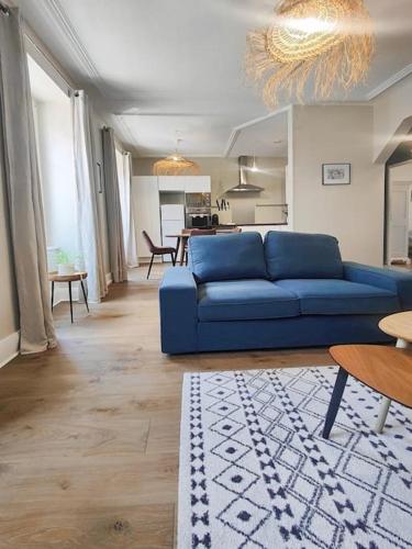 un salon avec un canapé bleu et une table dans l'établissement L'Haussmannien Moderne - Centre-ville - Elégant, à Mulhouse