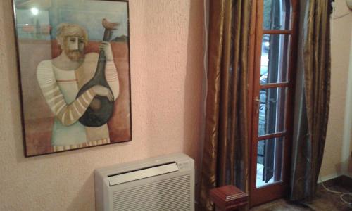 a painting of a man playing a guitar next to a window at Apartmani Vila Marija in Budva
