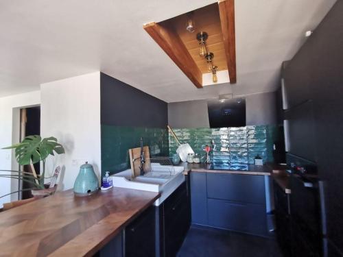 une cuisine avec des placards bleus et un comptoir en bois dans l'établissement Duplex atypique et chaleureux, hyper centre, à Bordeaux