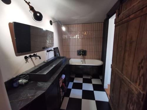 La salle de bains est pourvue d'un sol en damier noir et blanc. dans l'établissement Duplex atypique et chaleureux, hyper centre, à Bordeaux