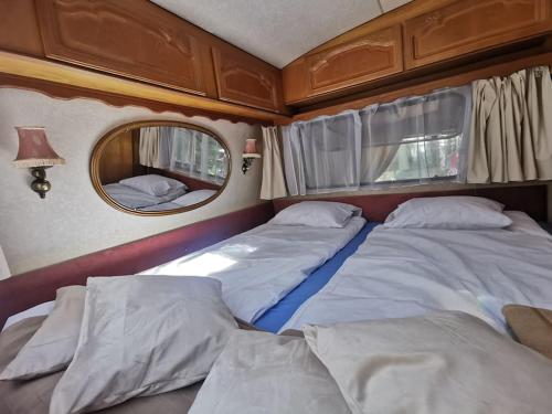 a room with two beds and a mirror at CampOloHel- przyczepa kempingowa in Hel