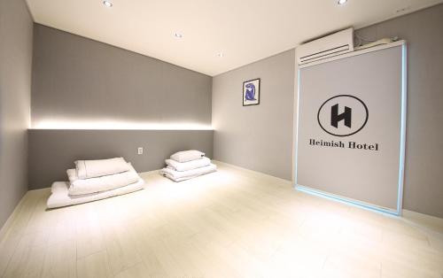 a room with two beds in the corner of a room at Heimish Hotel in Tongyeong