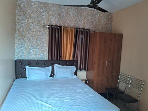 a bedroom with a blue bed and a chair at WB40 Guest House in Durgāpur
