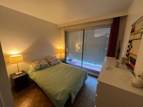 une petite chambre avec un lit et une fenêtre dans l'établissement Agréable Apartment 2 pièces, à Boulogne-Billancourt