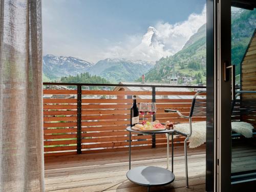 a table on a balcony with a view of mountains at Ascot Penthouse 160 m2 Matterhorn View in Zermatt