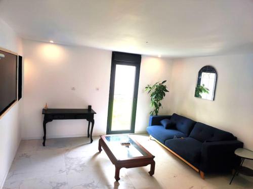 a living room with a blue couch and a piano at Appartement moderne proche Paris, aéroport et disneyland in Le Perreux-Sur-Marne