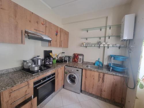 a kitchen with a washing machine and a dishwasher at Apprt Ennakhil 2 in El Jadida