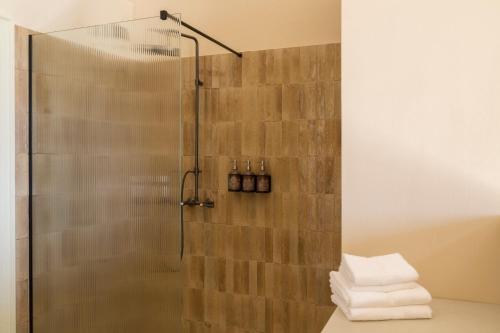 a bathroom with a shower with towels on a counter at Masseria Donna Menga - The Leading Hotels of the World in Torre Lapillo