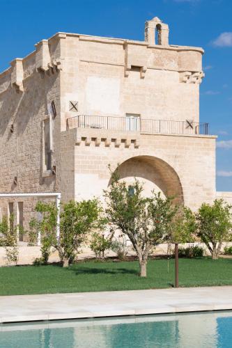 a building next to a body of water at Masseria Donna Menga - The Leading Hotels of the World in Torre Lapillo