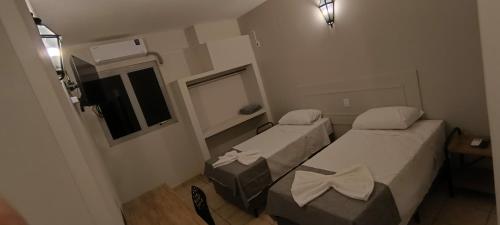 a small room with two beds and a window at Bravo City Hotel Sorocaba in Sorocaba