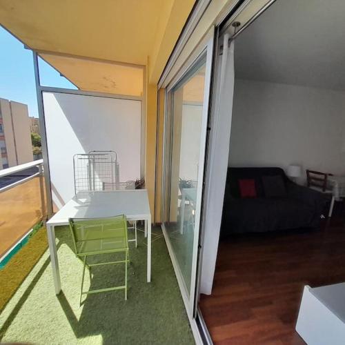 d'un salon avec une table et un canapé sur un balcon. dans l'établissement Spacieux Studio proche mer terrasse clim parking, à Six-Fours-les-Plages