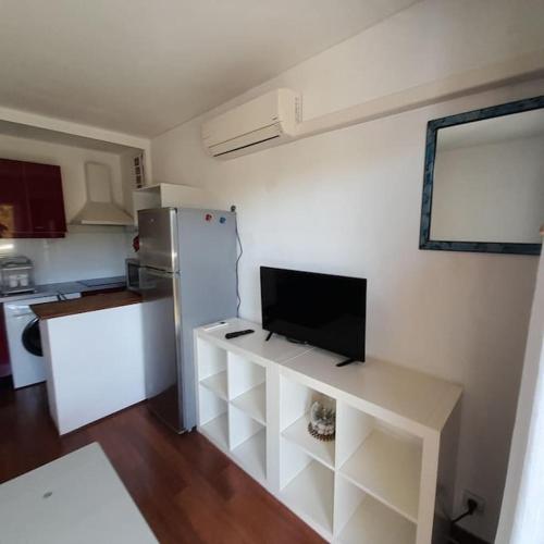 Il comprend une cuisine équipée d'un réfrigérateur et d'une télévision. dans l'établissement Spacieux Studio proche mer terrasse clim parking, à Six-Fours-les-Plages