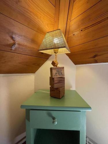a green table with a lamp on top of it at B&B - Chambres d'Hôtes Acoucoula in Orthez