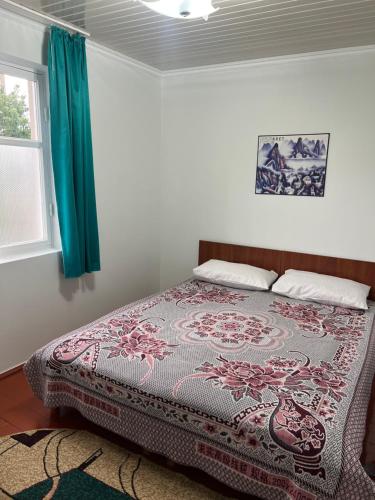 a bedroom with a bed with a patterned blanket at Абия in Cholpon-Ata